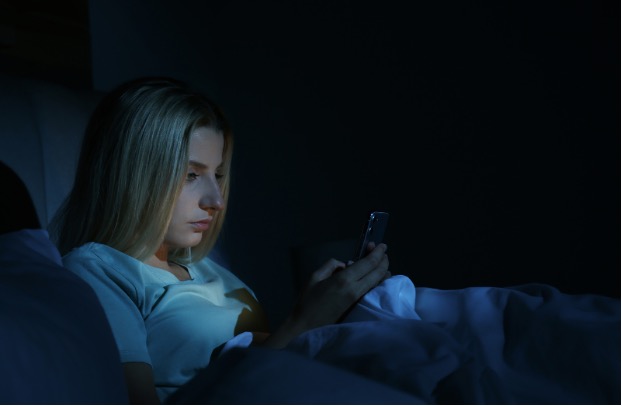 Woman using her phone in bed