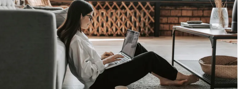 Smiling girl working in sitting room with cup of tea
