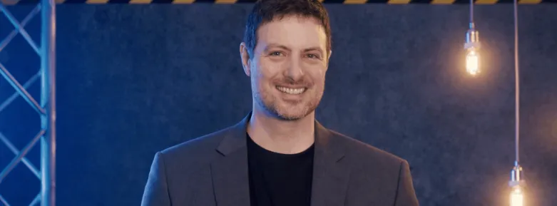 a man wearing a suit and tie smiling at the camera