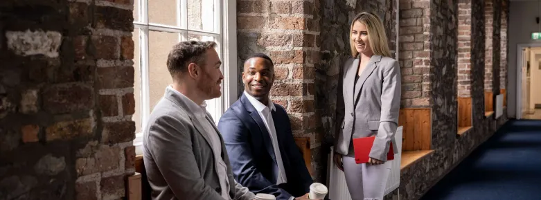 learners chatting in front of a brick wall