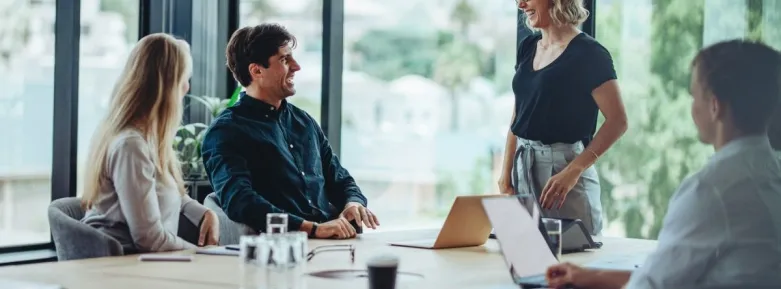 a group of people sitting at a table using a laptop