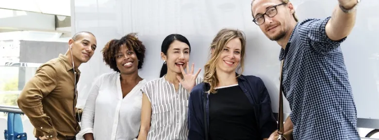 A smiling group recording a video on a phone