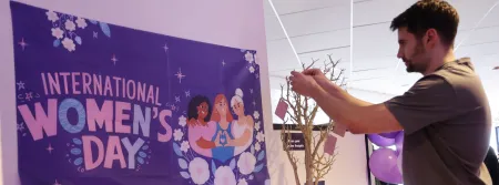 A person adding a note to a positivity tree