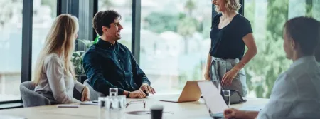 a group of people sitting at a table using a laptop
