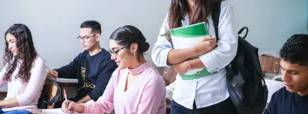Student walking through classroom between other students