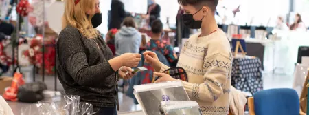 Two people making a purchase at a christmas market