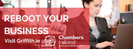 A woman using her laptop at a table to access the Chambers Ireland and Griffith College business planning course
