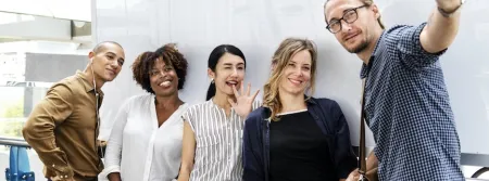 A smiling group recording a video on a phone