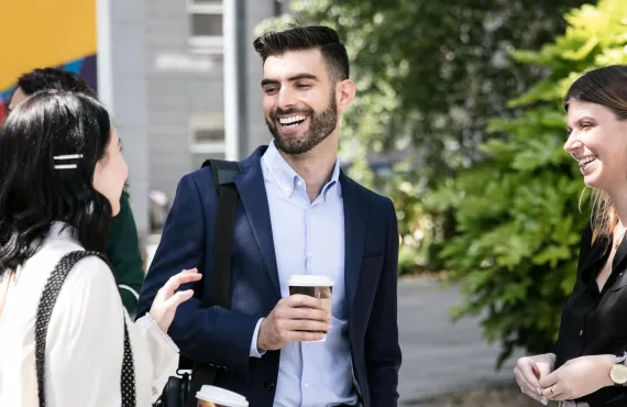 Group of students in formal attire talking to each other, smiling