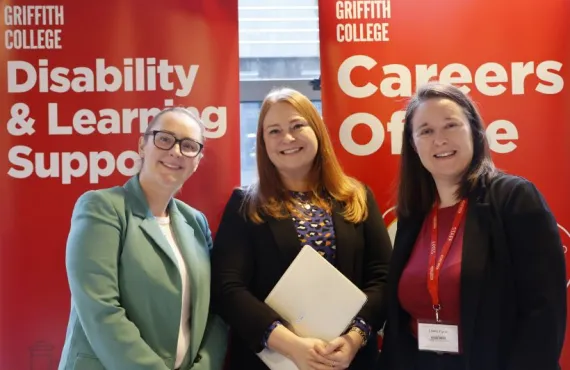 Griffith College staff smiling in front of information stands at Spring Induction 2026