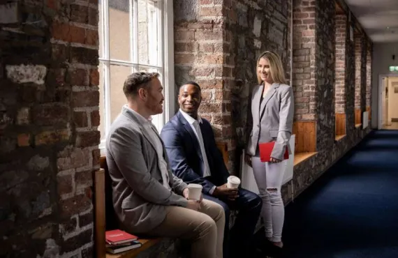 learners chatting in front of a brick wall
