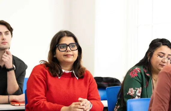 a group of people looking at a laptop