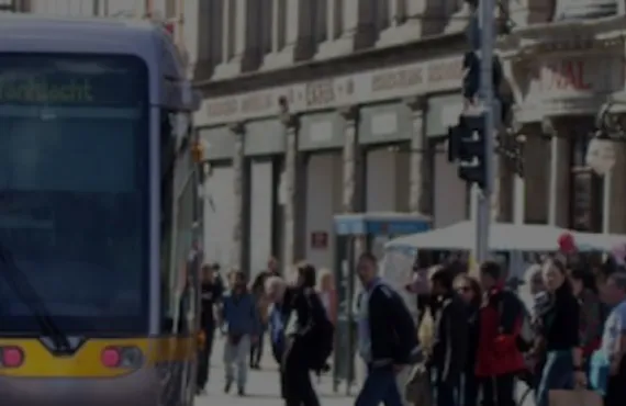 a group of people walking down a street next to a bus