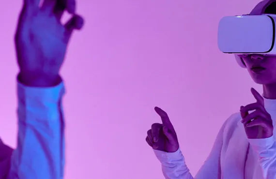Image of a girl with a VR headset on with pink lighting, futuristic