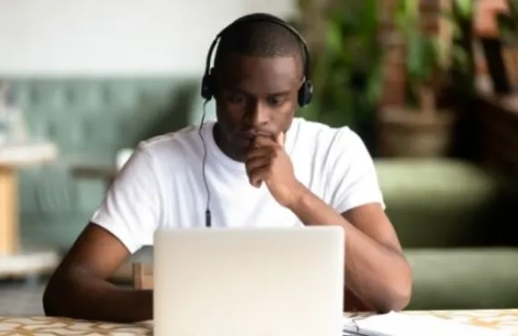 a man sitting at a table using a laptop