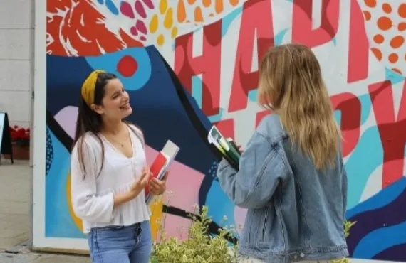person,outdoor,standing,building,holding,kite,colorful,man,looking,woman,young,front,boy,child,girl,wearing,hand,orange,talking,little,umbrella,group,walking,large,sign,people,street,phone,display,store,playing