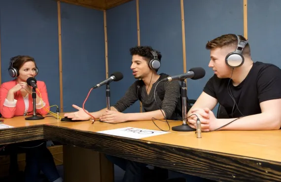 a group of people sitting at a table with a laptop