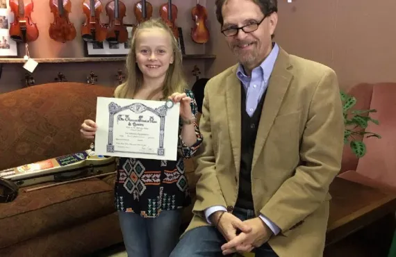 Abi Snell in 2019 with her music teacher and her Level 3 Certificate