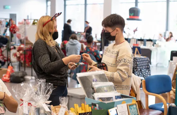 Two people making a purchase at a christmas market