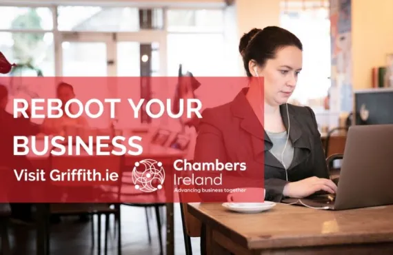 A woman using her laptop at a table to access the Chambers Ireland and Griffith College business planning course