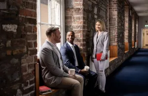 learners chatting in front of a brick wall