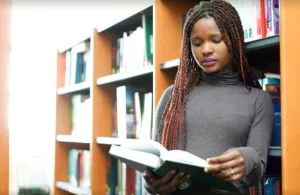 a woman standing in front of a book shelf