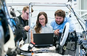 Three apprentices around a computer