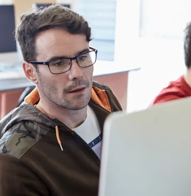 a group of people looking at a laptop