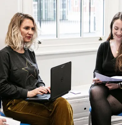 a group of people looking at a laptop