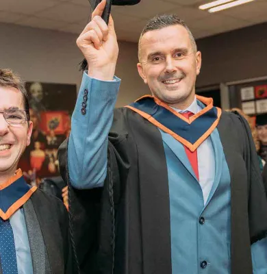 a man standing in front of a group of people posing for the camera