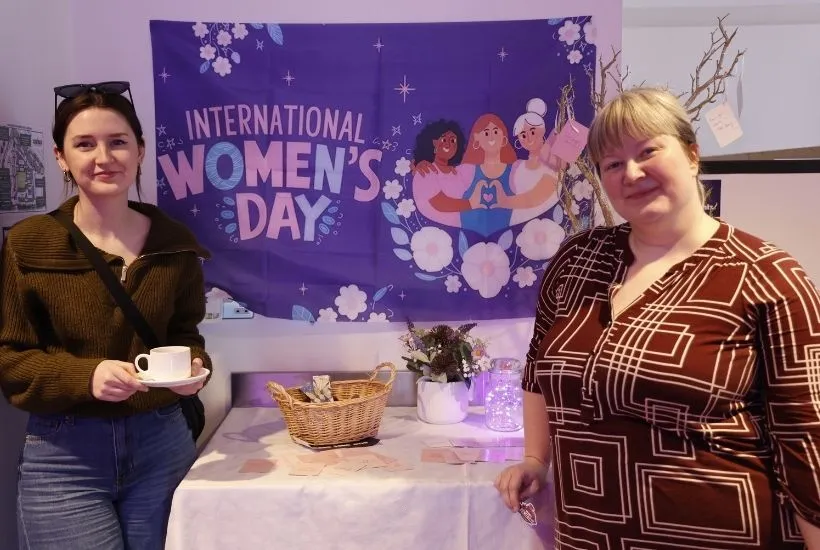  Two people standing in front of an International Women's Day flag at Griffith College