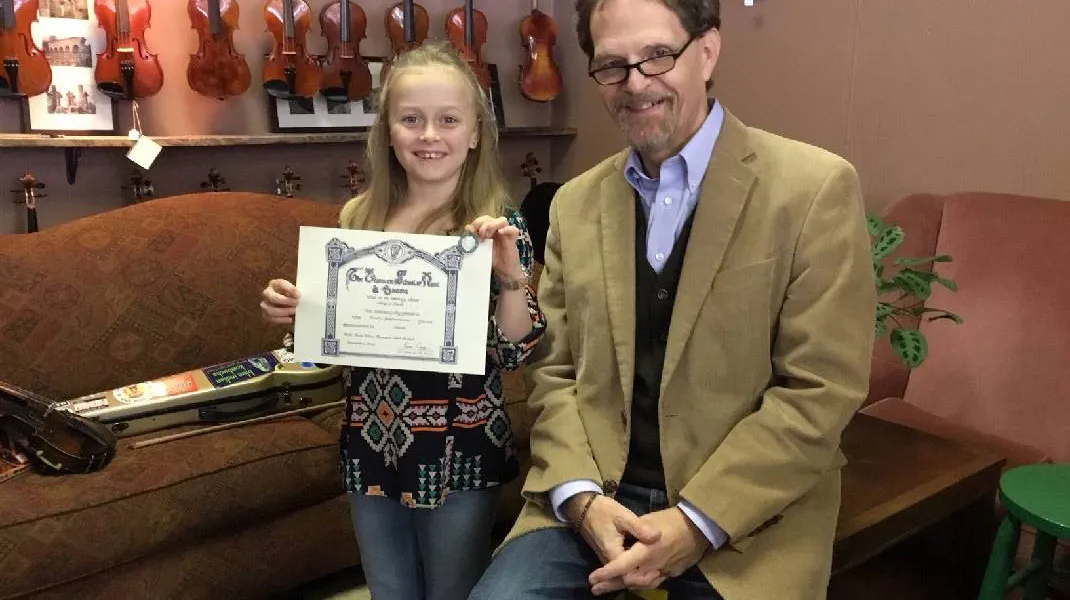 Abi Snell in 2019 with her music teacher and her Level 3 Certificate