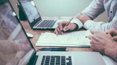 a man sitting at a table using a laptop computer