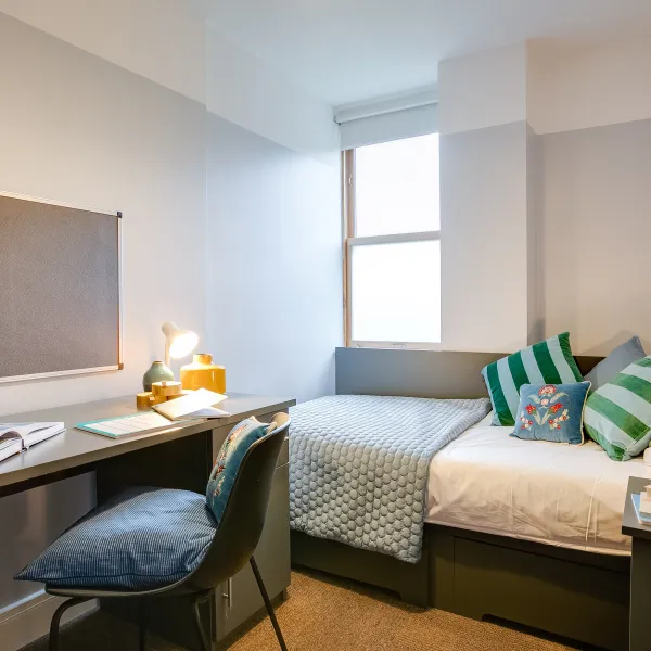 a bedroom with a bed and desk in a room