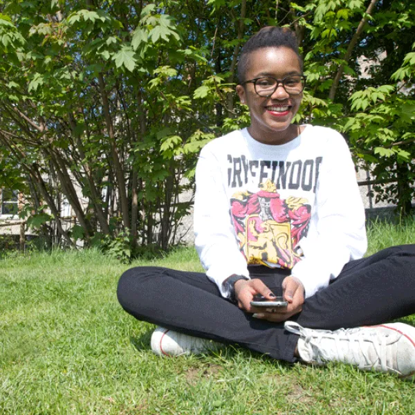a young man is sitting in the grass