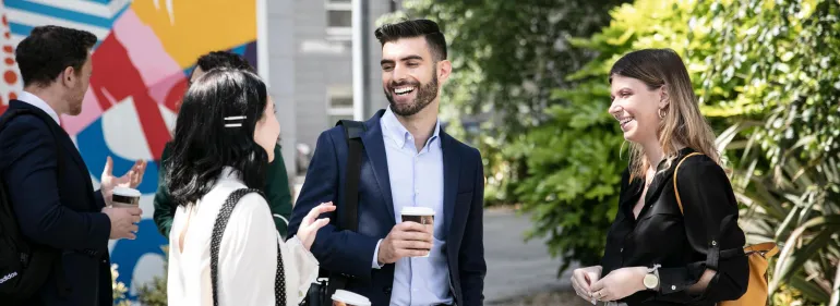 Group of students in formal attire talking to each other, smiling