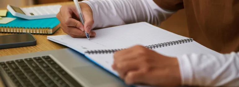 a person using a laptop computer sitting on top of a wooden cutting board