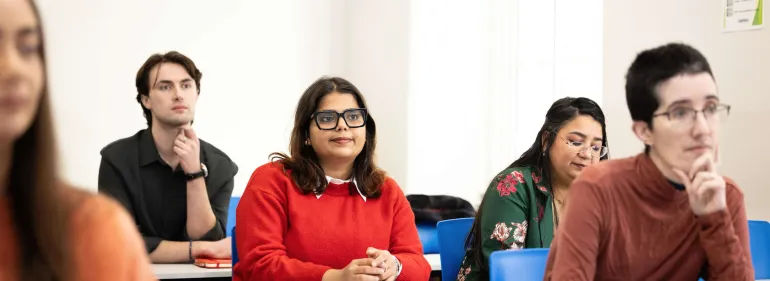 a group of people looking at a laptop