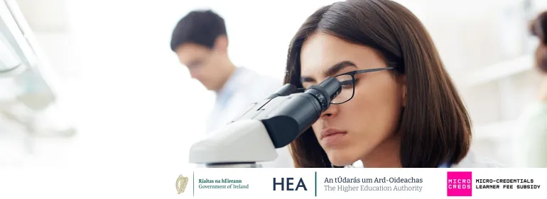  a woman looking through a microscope