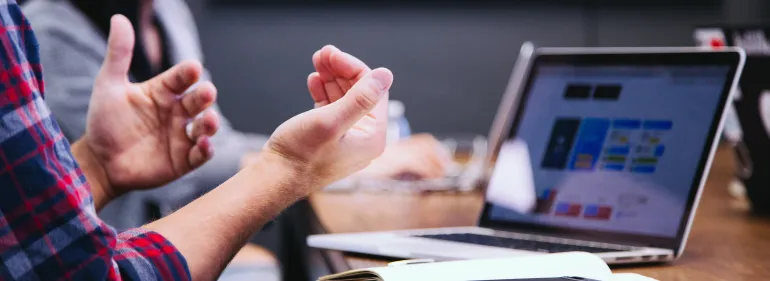 a person using a laptop computer sitting on top of a table