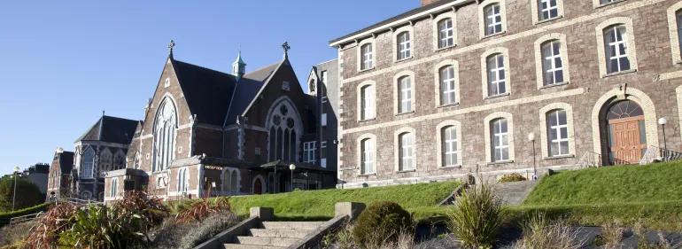 a large brick building with grass in front of a castle