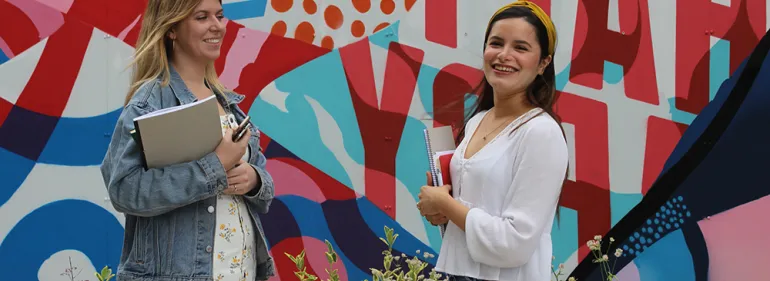 Two students standing in front of a Griffith College graffiti wall