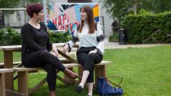 a woman sitting on a bench in a park