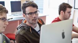 a group of people looking at a laptop