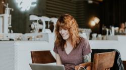a woman sitting on a chair in front of a laptop