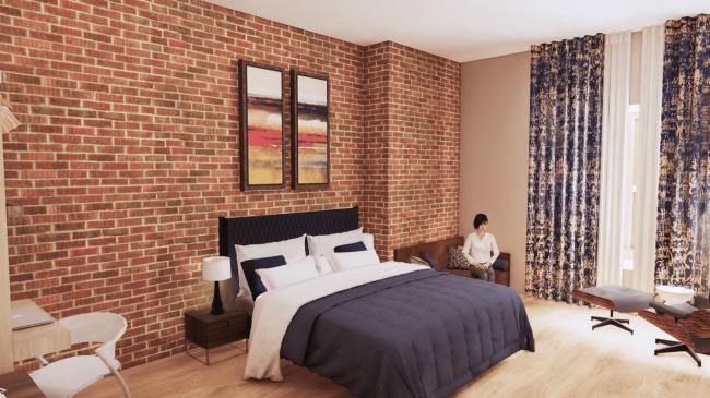 Boutique hotel bedroom with brick wallpaper, navy bedding, patterned curtains and lounge seating.