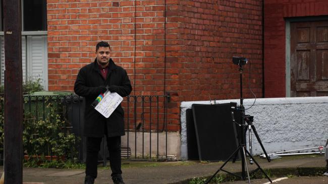 a man standing in front of a brick building