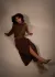 Model wearing matching quilted shawl and wrap skirt, sitting