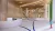Pictured is a double-height reception space with a desk, seating area and ceiling details. There is a pathway drawn on the floor and a mezzanine level is visible in the background. 