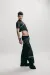 Male model wearing a black denim top and black denim jeans with a chain and black boots.